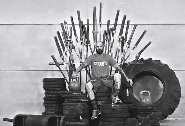Coach sentado en un trono de barras y neumáticos, en blanco y negro